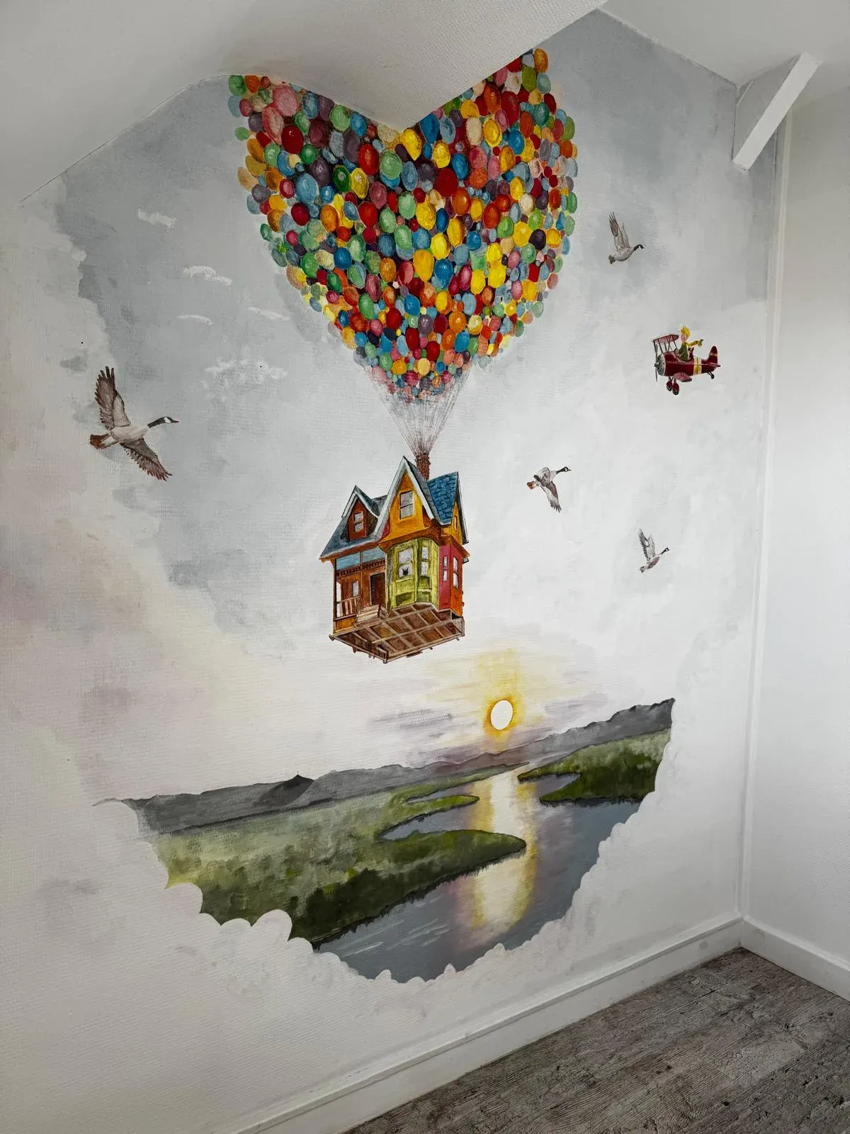 Fresque murale inspirée du film Là-haut : maison volante, ballons colorés et paysage au coucher du soleil